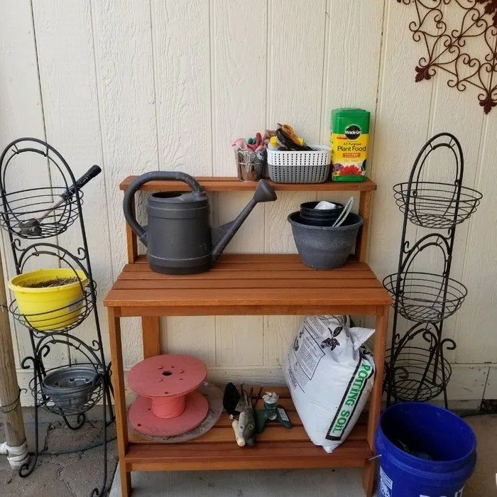 Reviewer's photo of the potting bench holding gardening tools.