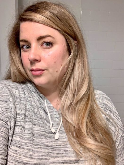 A reviewer showcasing their sleek, blow-dried hair after using the product