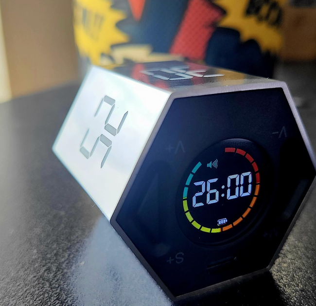 A hexagonal timer flipped to its side, displaying a black digital countdown starting from 26.