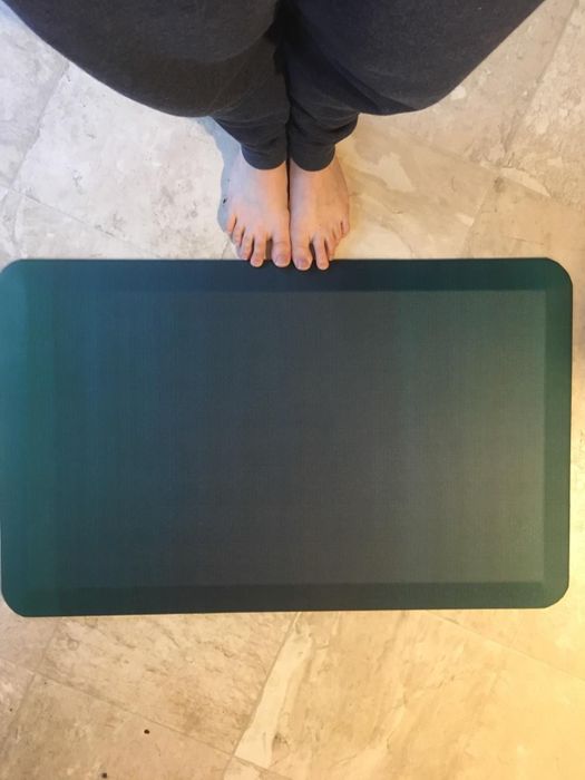 The reviewer is seen standing in front of the anti-fatigue mat.