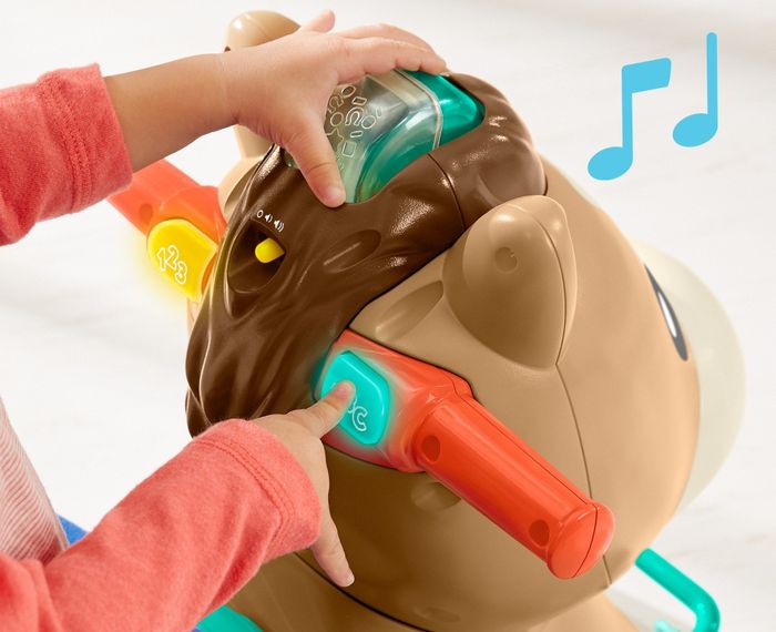 A child pressing a button on a pony toy and it lighting up