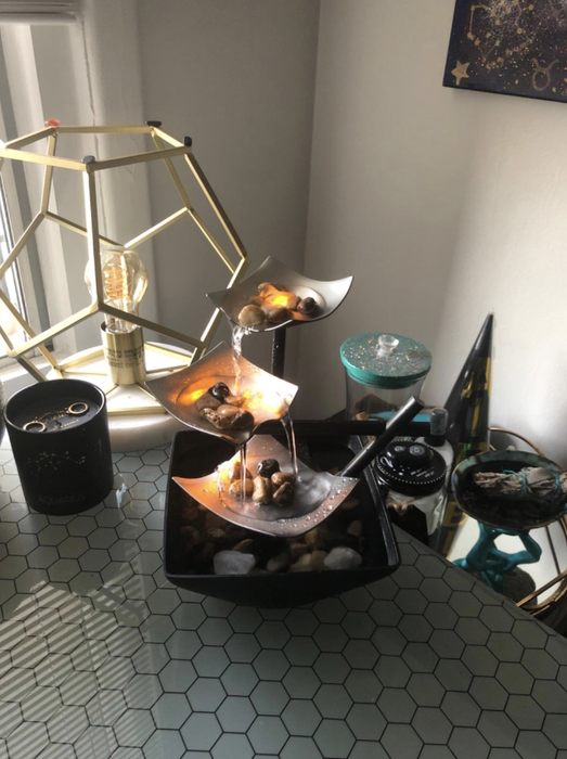 A reviewer’s image showing the three-tiered small waterfall with metal plates, displayed in a home setting.