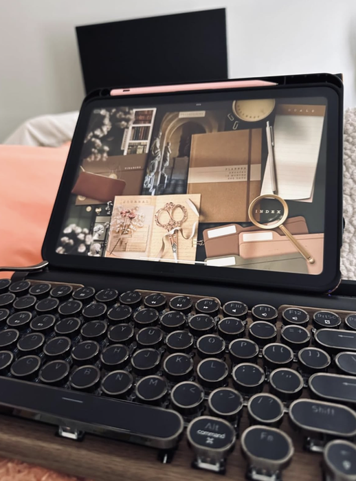 A black retro-style typewriter Bluetooth keyboard attached to an iPad