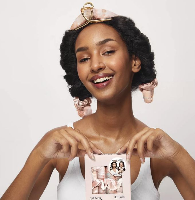 model styling their hair with the heatless curling set in place