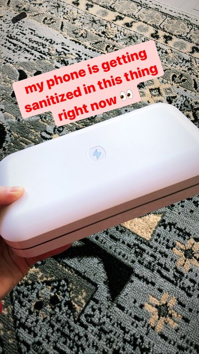 The writer holding the sanitizer, with the caption.