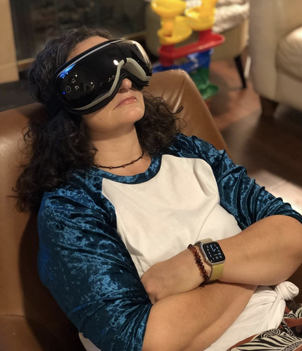 Reviewer wearing a black over-the-eye massager mask
