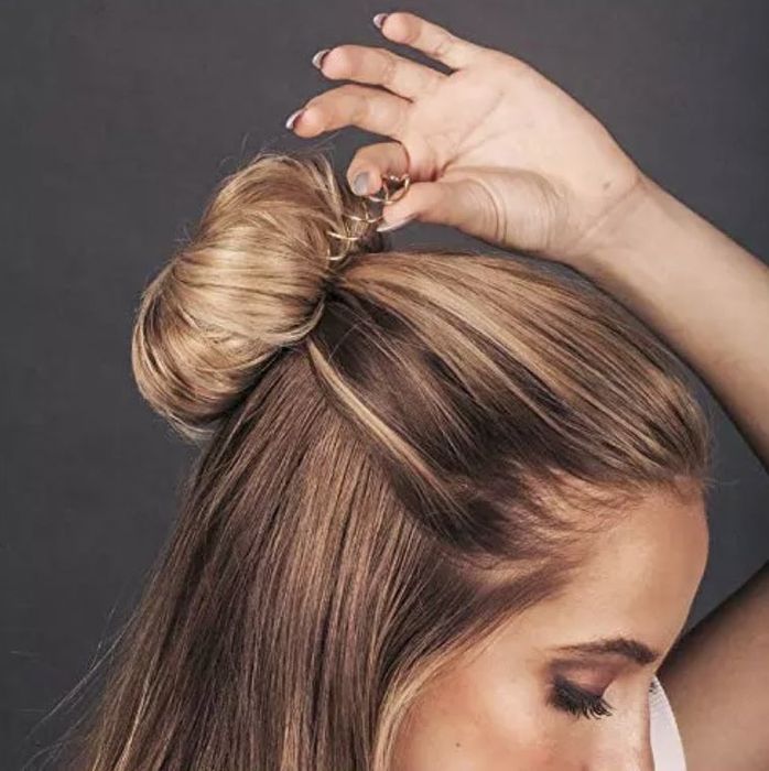 A model securing their hair with the pin