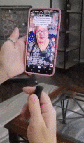 A reviewer demonstrates using a small black ring to navigate through TikToks effortlessly.