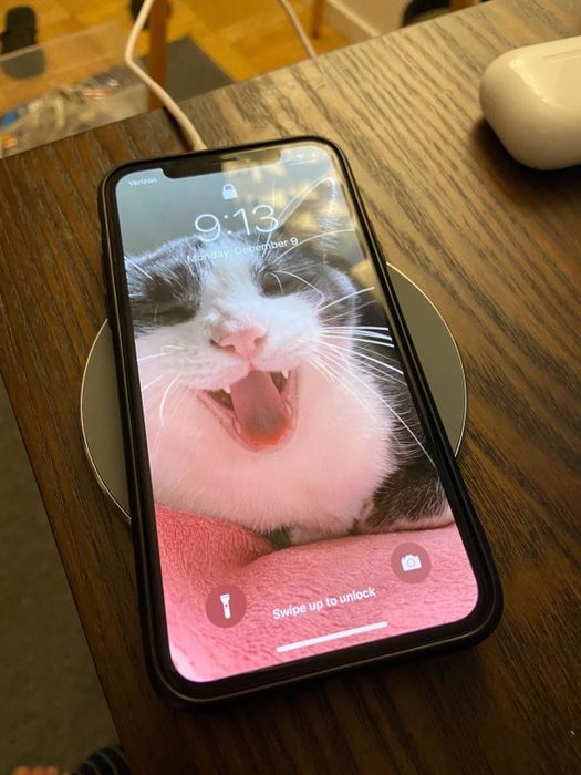 A phone charging on a sleek wireless charger.
