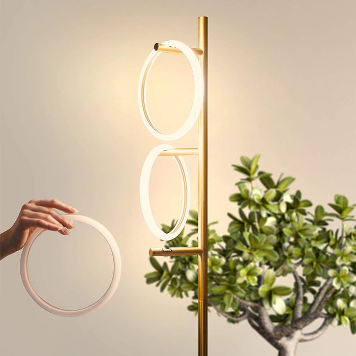 A model carefully placing one of the light rings onto the branch of the floor lamp.