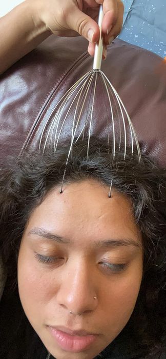A reviewer using the head massager