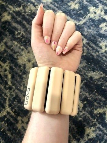 A Mytour writer shows their arm with a beige Bala Bangle wrapped around their wrist, demonstrating its use.