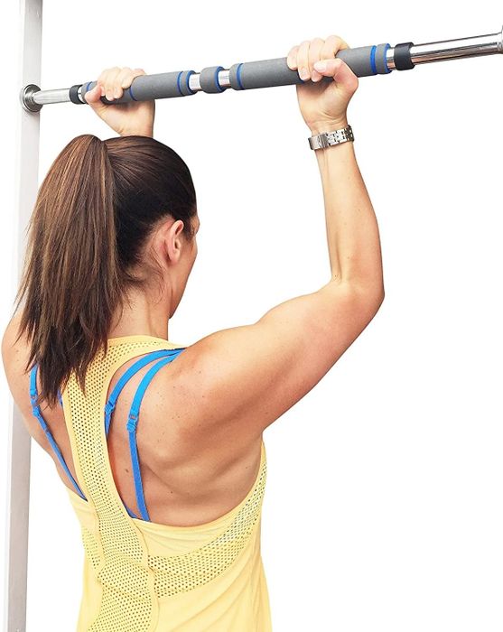 A model performs pull-ups using the doorway pull-up bar.
