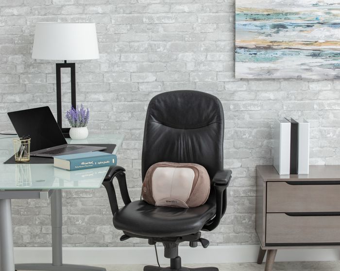 brown massage pillow on a black office chair
