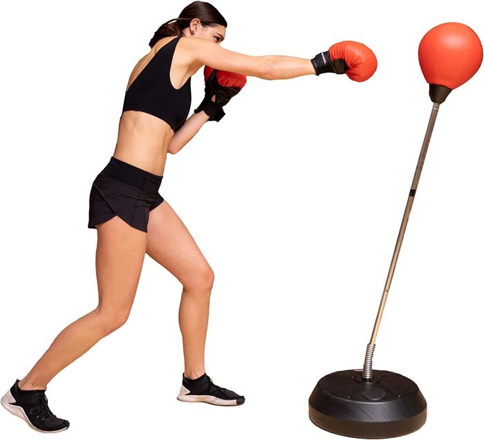 Model throws punches at a red punching bag stand.