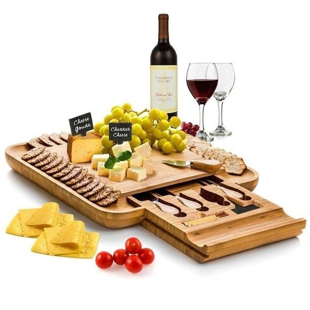 wooden cheese board filled with an assortment of cheeses and fresh fruits
