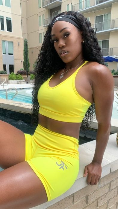 Model showcases a bright yellow v-neck sports bra paired with matching bike shorts for an energetic, sporty look.