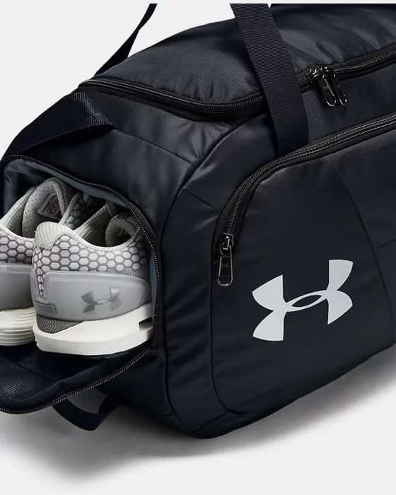 A black gym bag featuring a sneaker compartment on the side and a front pocket for easy access to smaller items.