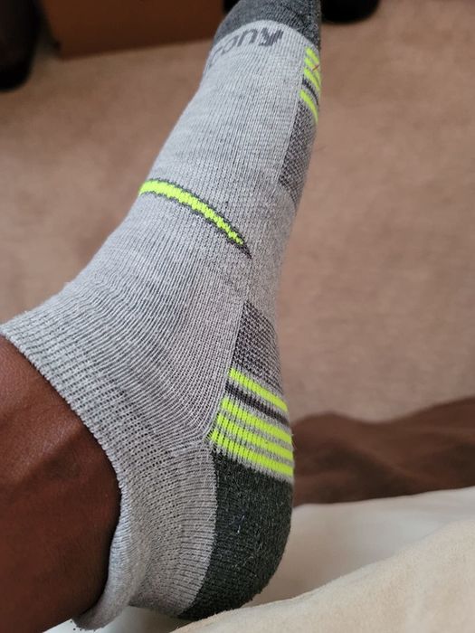 A photo of a reviewer showing one foot wearing the athletic sock.