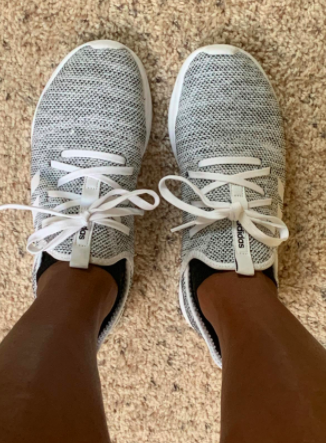 Reviewer sports gray Adidas Cloudfoam running sneakers with white laces.