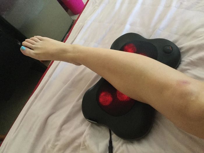 A reviewer using the massager on their calf