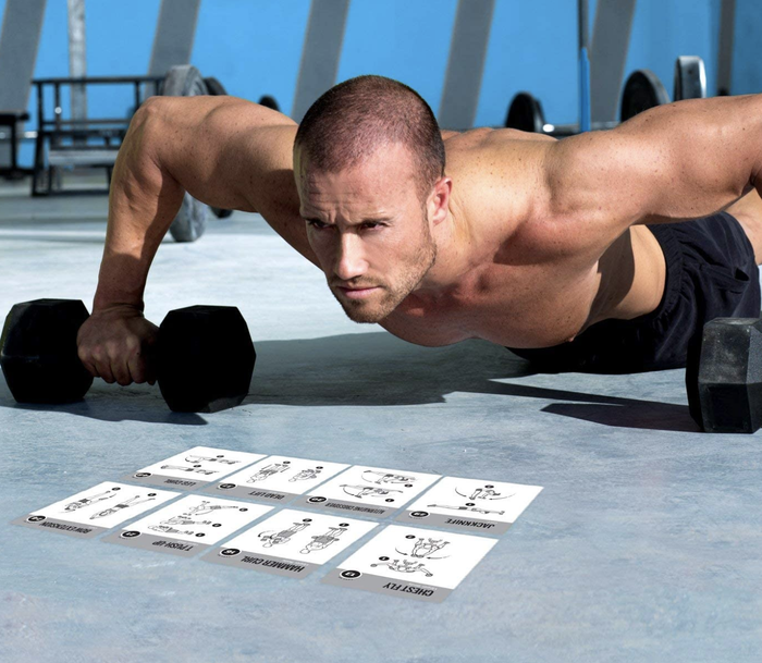 A model demonstrates a push-up with black dumbbells placed in front of a row of exercise movement cards