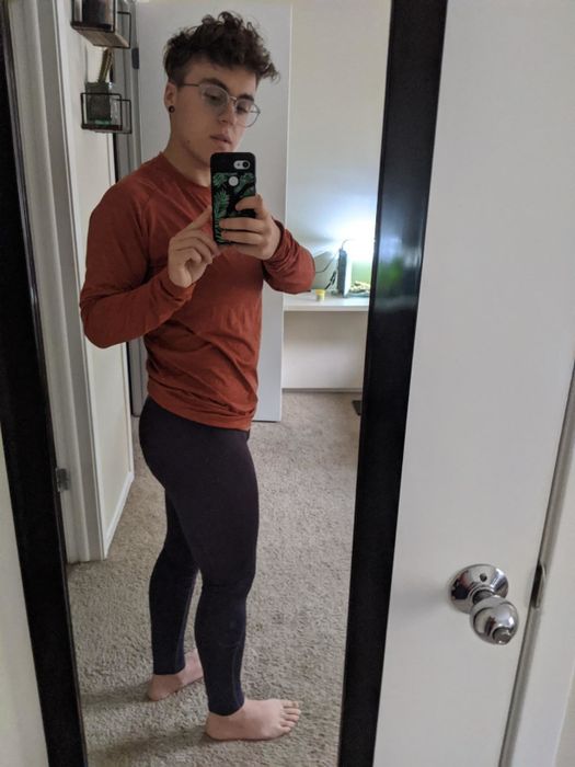 The reviewer is wearing black thermal compression leggings paired with a red running top.
