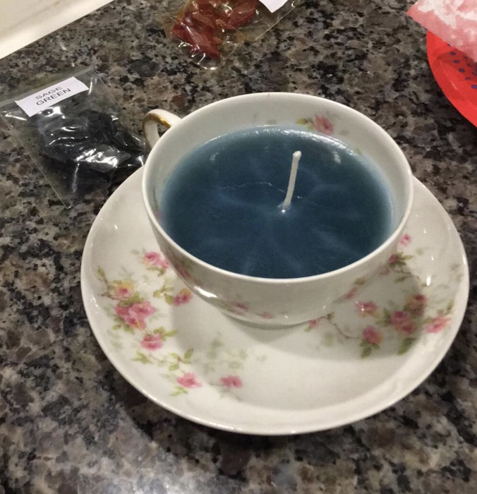 A candle crafted by the reviewer inside a teacup.
