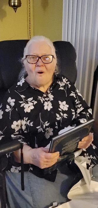 A reviewer happily holding a copy of the book with excitement