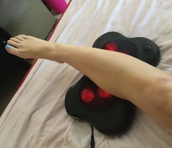 a reviewer relaxing with their calf resting on the massager
