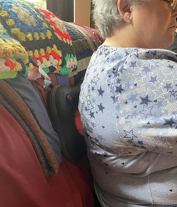 a reviewer sitting with the massager positioned against their back