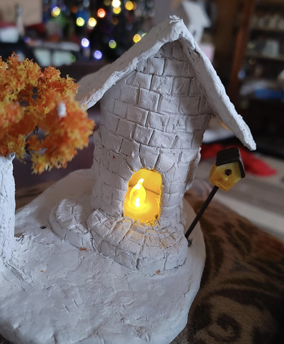 The reviewer's clay model home with a small tea light glowing inside.