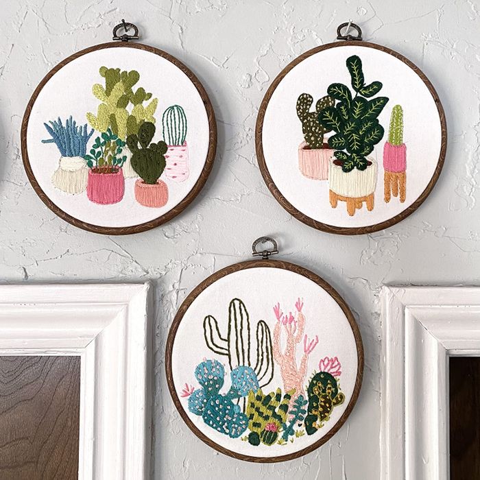 The reviewer's three embroidered pieces displayed on a wall.
