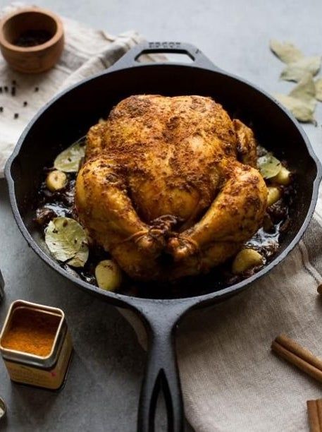 cast-iron skillet cooking a whole chicken