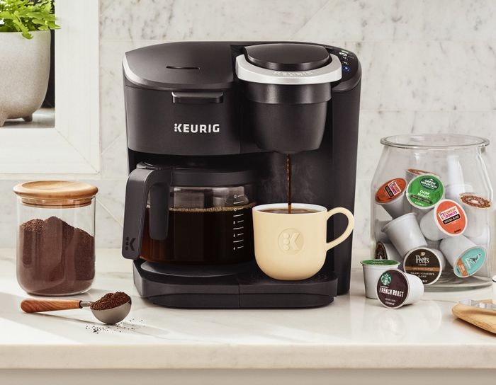 black Keurig coffee machine with a pot on one side and a single mug on the other