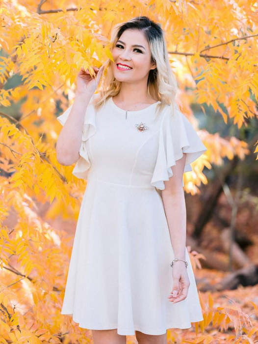 A reviewer in a classic white dress.