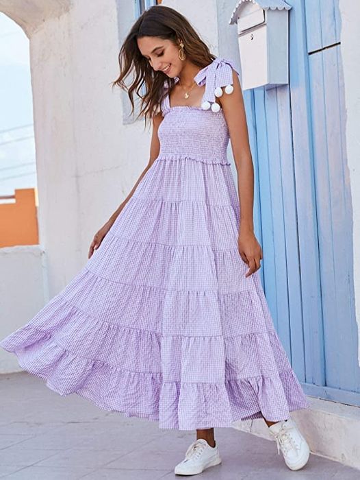 A model showcasing a stylish long-tiered maxi dress paired with sneakers.