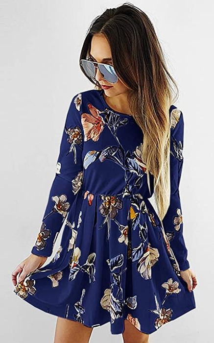 A model is seen wearing a navy blue dress with floral patterns.