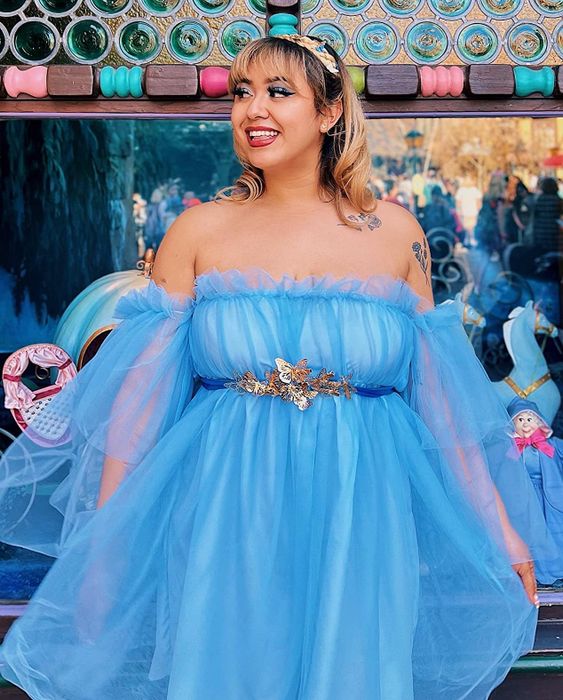 A reviewer wearing a light blue off-the-shoulder gauzy dress.