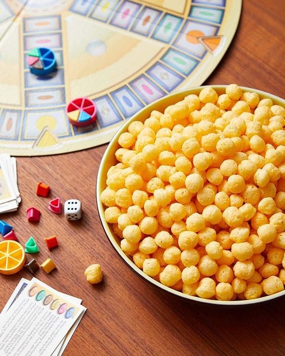 a bowl of cheese balls placed next to a board game