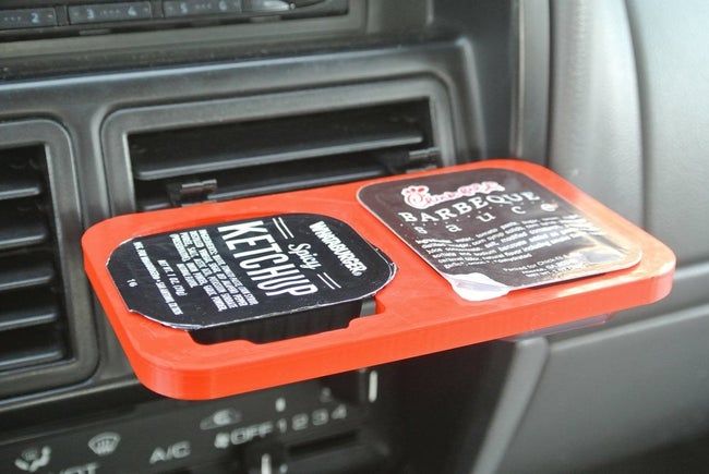 A holder designed to hold two dips, attached to a car vent for easy access while on the road.