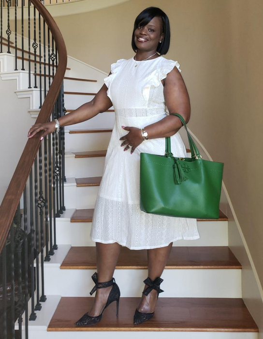 A reviewer is seen wearing a white dress.