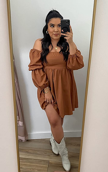 A reviewer rocking a brown dress with white cowboy boots.