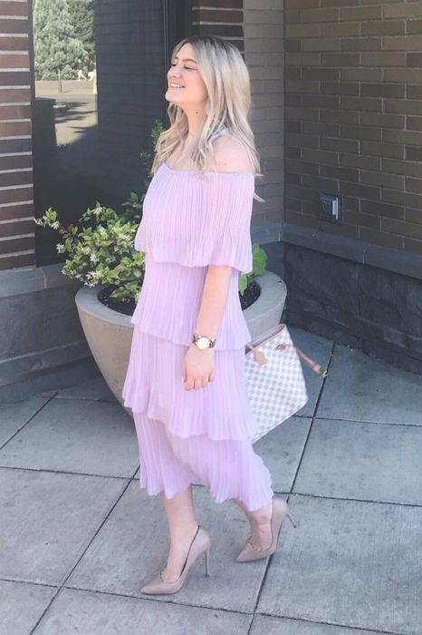 A reviewer showcases a pink dress in this photo.