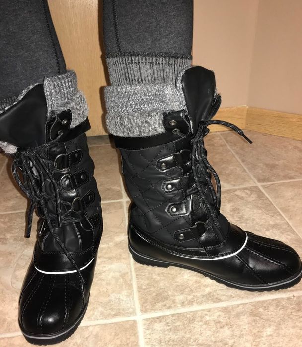 A reviewer showcasing the boots in black