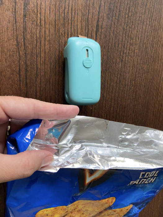 a reviewer holding a bag of chips that has been resealed using the bag sealer