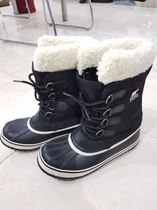 Image of tall boots with a tie-up front, rubber soles, and a footbed lined with faux fur on top