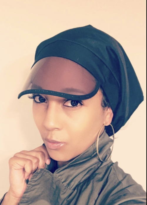 The reviewer is wearing a black, flexible cap with a small plastic visor on top of their head.