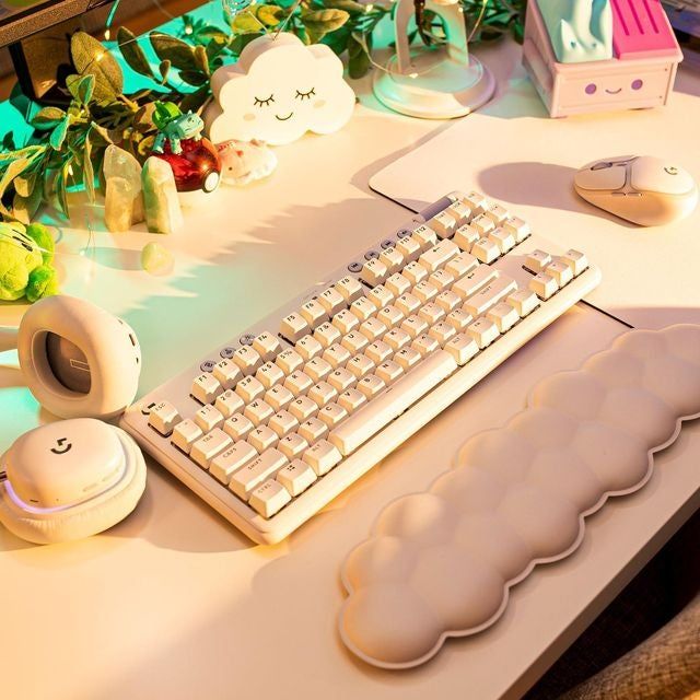 A white Logitech keyboard paired with a plush cloud wrist rest