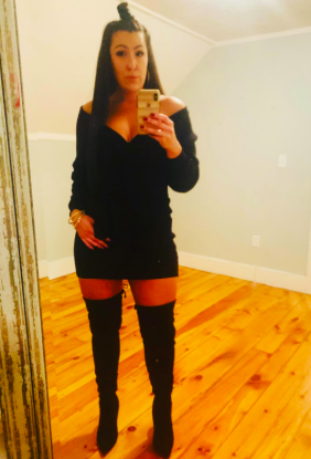 A reviewer styled in the black dress paired with over-the-knee boots